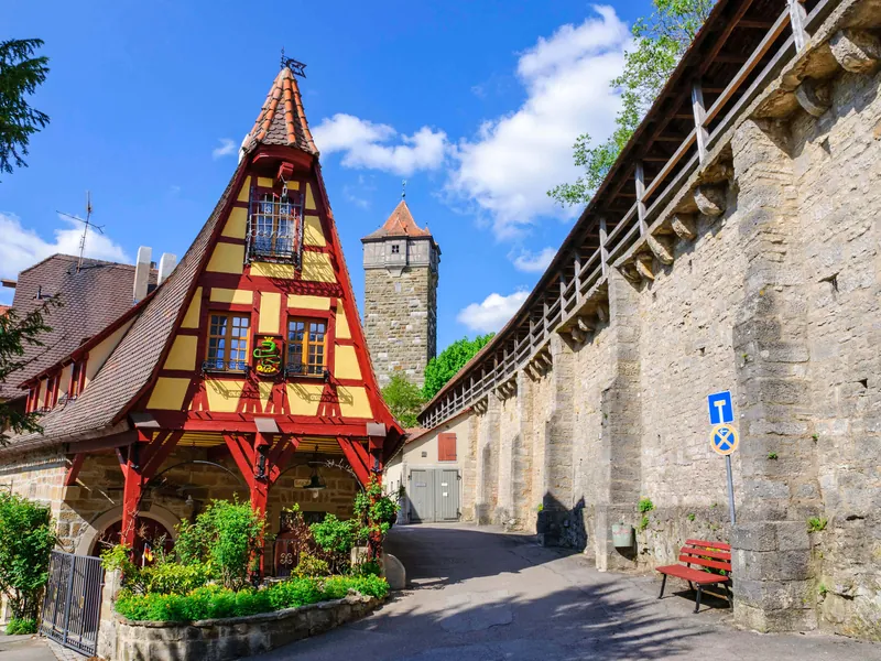 Covered walkway along the town wall of Rothenburg with a tower behind